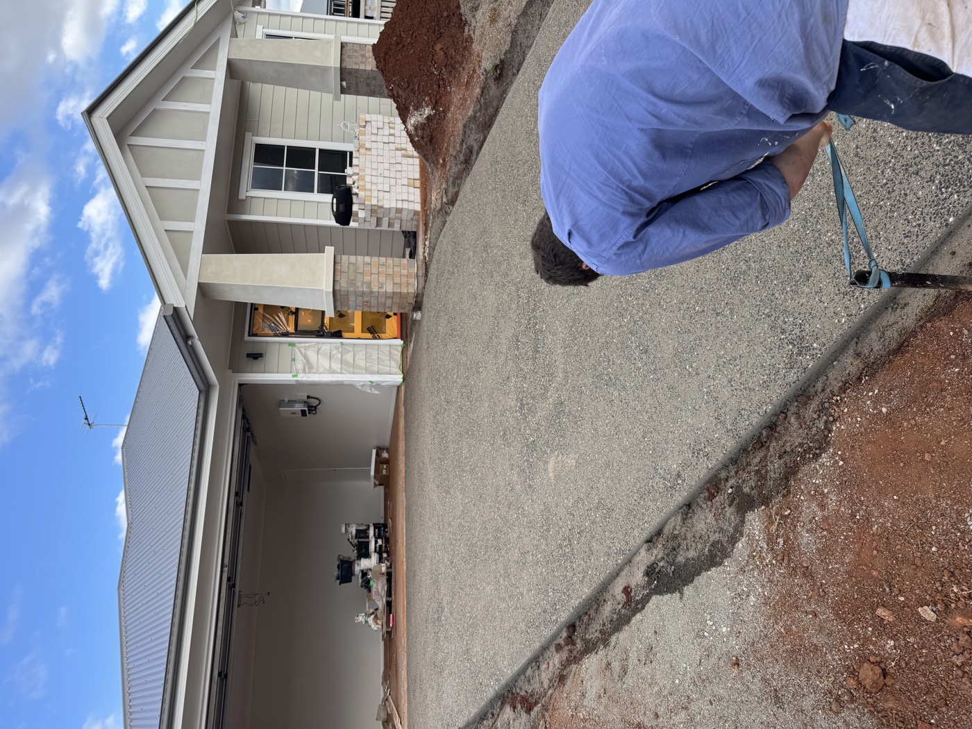 Exposed aggregate concrete driveway poured beside a new home